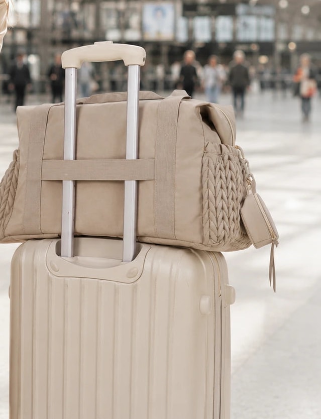 Securidou hospital bag slipped over the handle of a suitcase, at a station