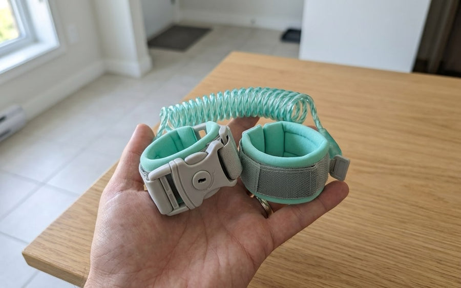 Coiled cord folded up and two padded mint green wristbands in the palm of a hand