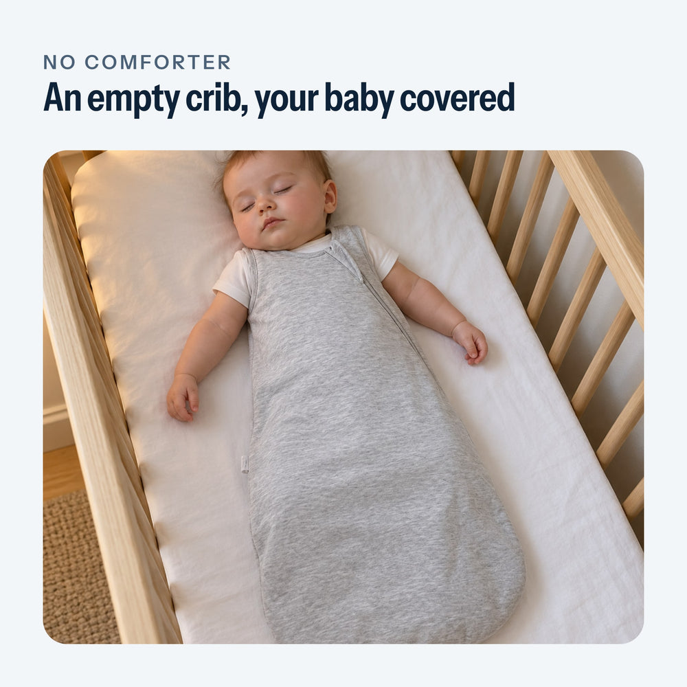 Baby asleep on their back in the gray sleep sack, in an empty crib
