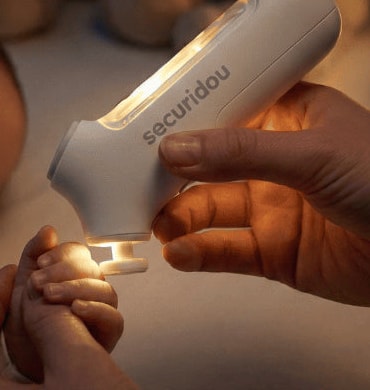 The illuminated head of the Securidou electric nail file on a baby's fingers