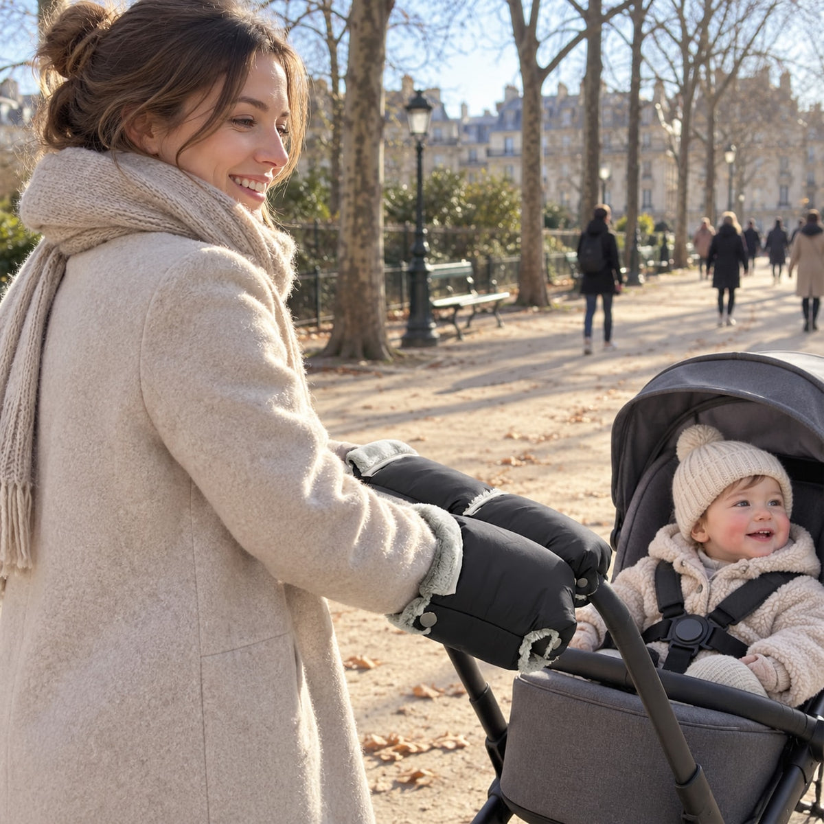 Parent pushing the stroller in winter, both hands in the black Securidou mittens fastened to the handlebar