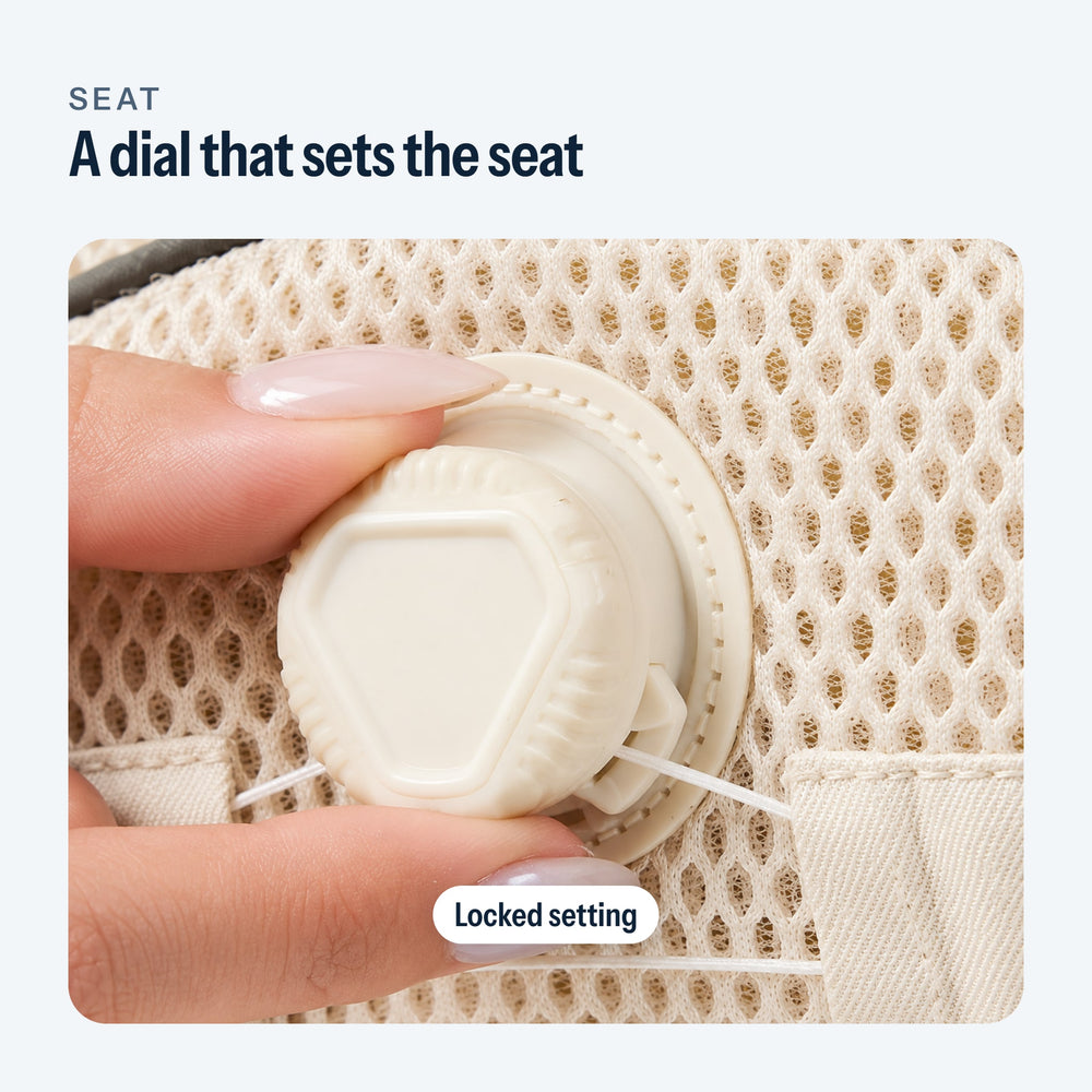 Fingers turning the seat adjustment dial of the baby carrier