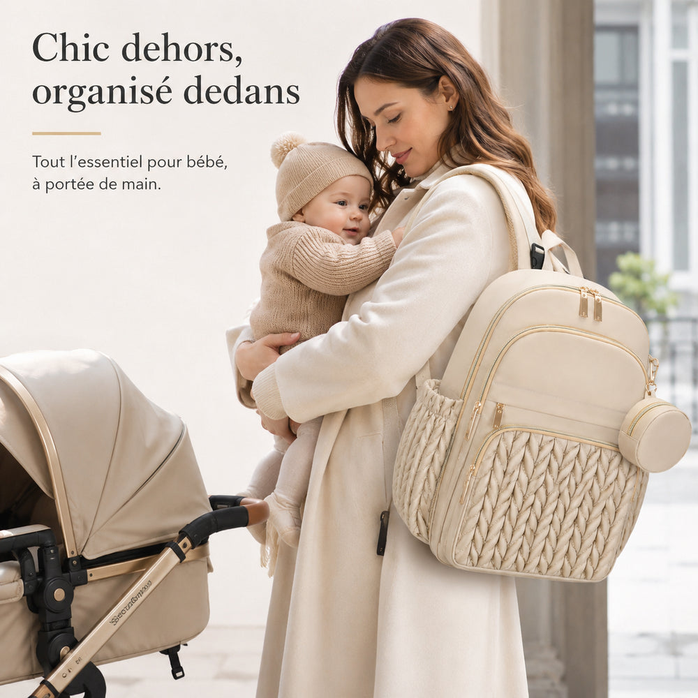 Mum wearing the beige Securidou diaper bag backpack on an outing, holding her baby next to the pushchair